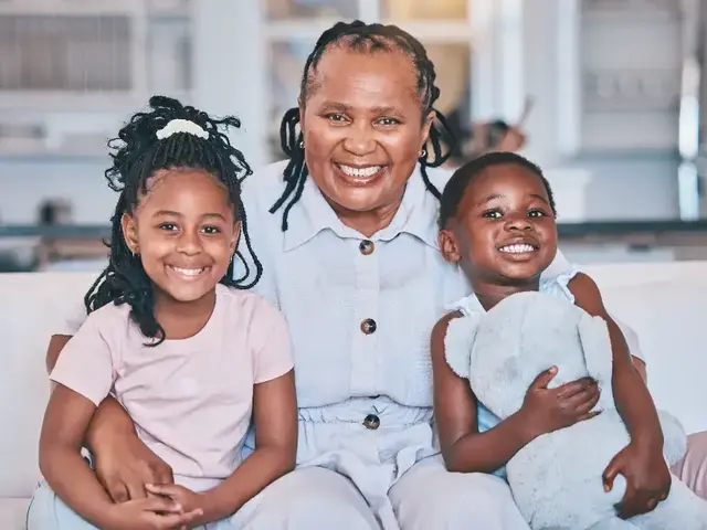 Grandmother sitting on a sofa with two smiling children
